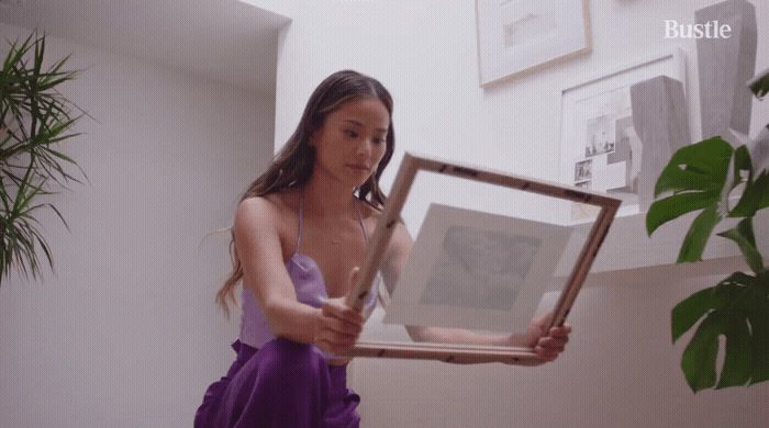 a woman in a purple dress holding a picture frame