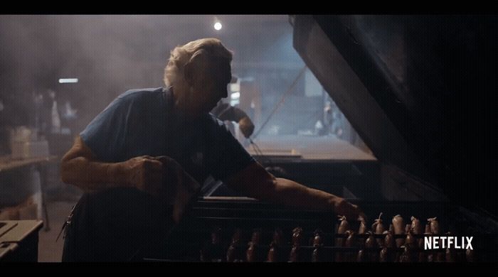 a man sitting at a piano in front of a microphone