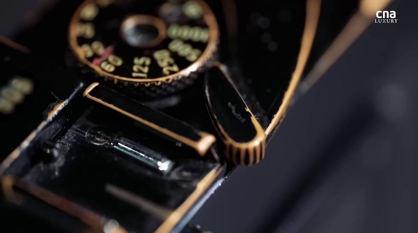 a close up of a black and gold watch