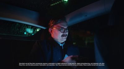 a man sitting in a car looking at his cell phone