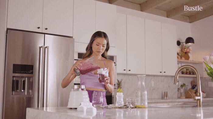 a woman standing in a kitchen preparing food