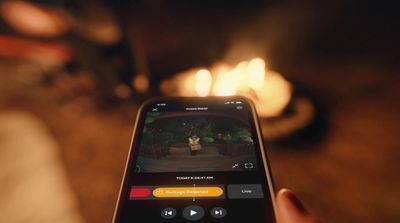 a person holding a cell phone in front of a fire