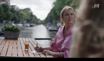 a woman sitting at a table with a glass of orange juice