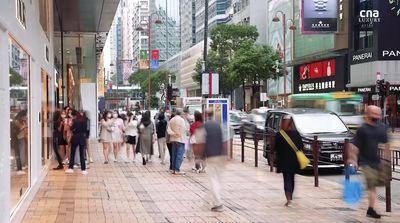 a crowd of people walking down a street next to tall buildings