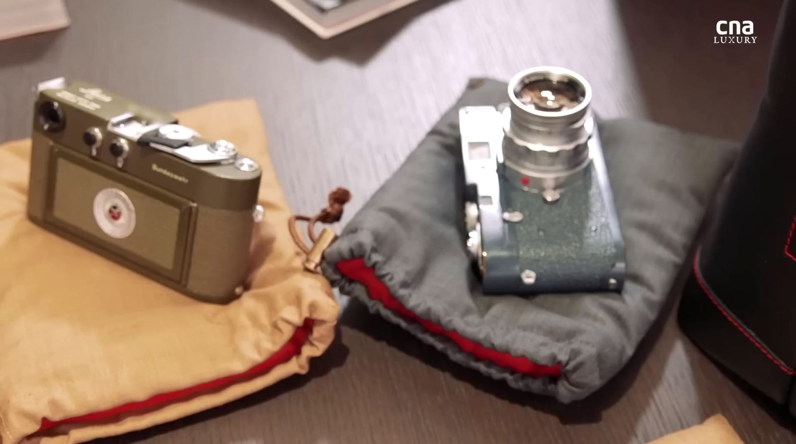 a camera sitting on top of a cloth next to a pillow