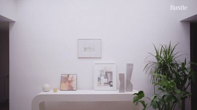 a room with a plant and pictures on the wall