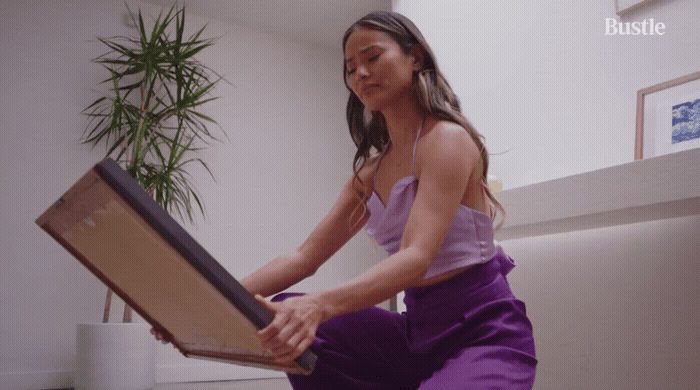 a woman in a purple dress is holding a suitcase