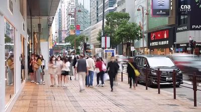 a group of people walking down a street next to tall buildings