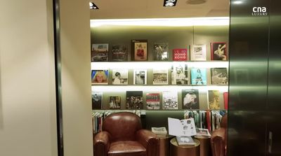 a brown chair sitting in front of a book shelf