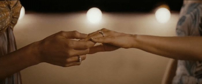 a close up of two people holding hands