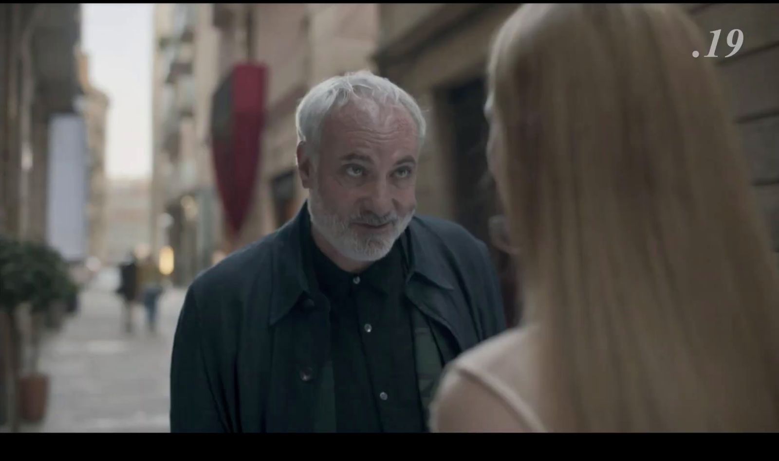 a man standing next to a woman on a street