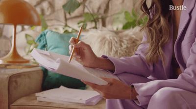 a woman sitting on a couch holding a pen and paper