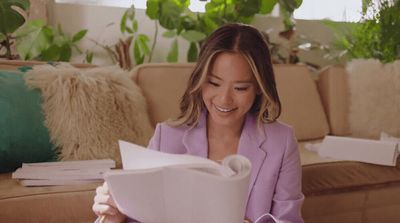 a woman sitting on a couch reading a book