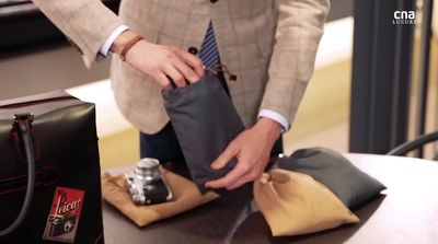 a man in a suit putting a bag on a table