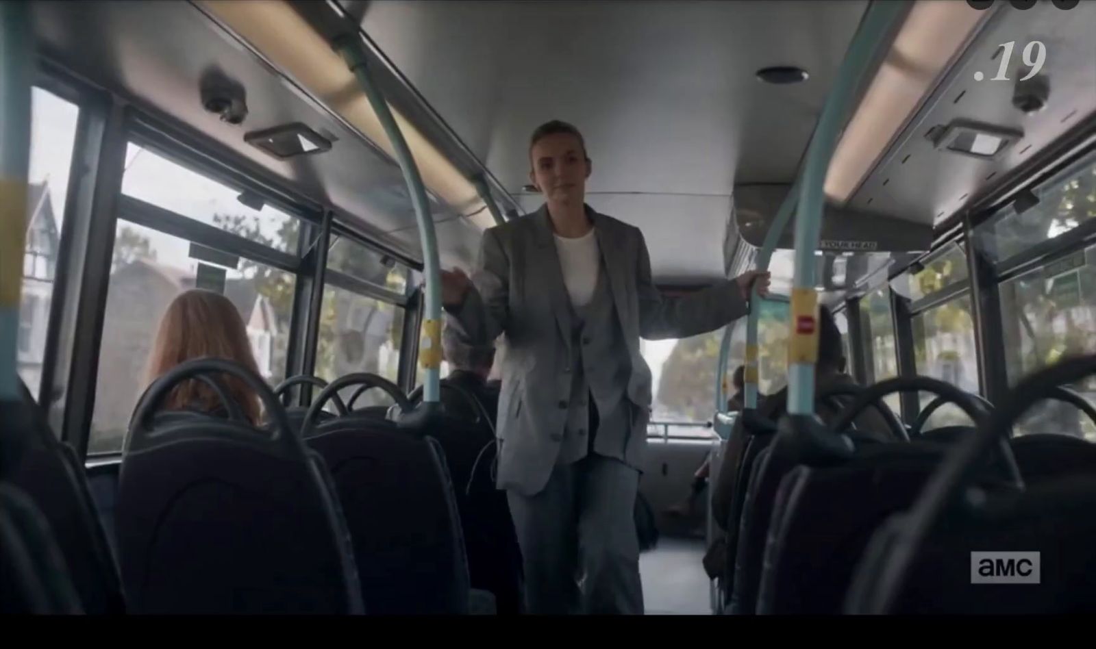 a man standing on a bus holding a bottle