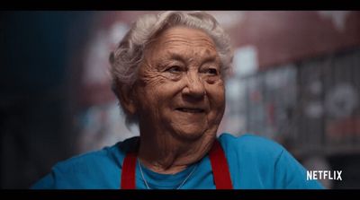 an old woman with a red apron on