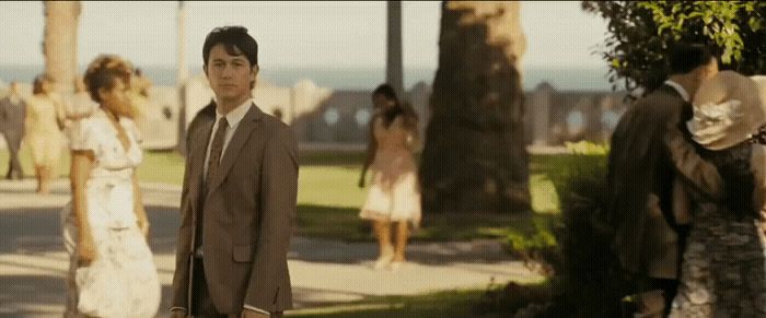 a man in a suit and tie standing on a sidewalk