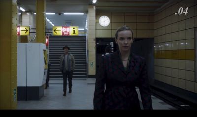 a woman standing in a subway station next to a man