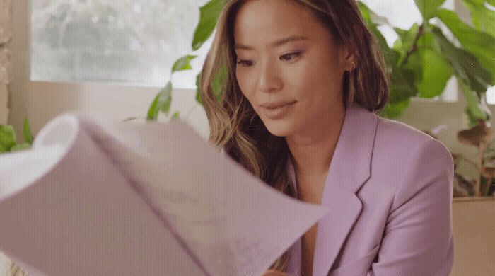 a woman sitting on a couch holding an umbrella