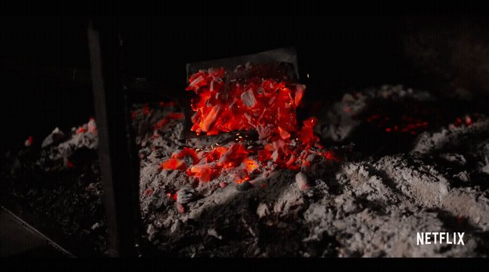 a pile of coal with red flames coming out of it