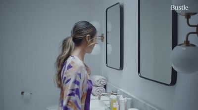 a woman standing in front of a bathroom sink