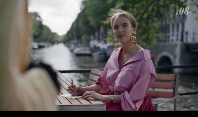 a woman in a pink dress sitting at a table