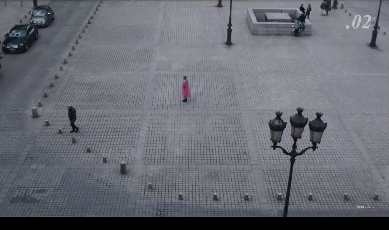 a woman in a pink dress walking down a street