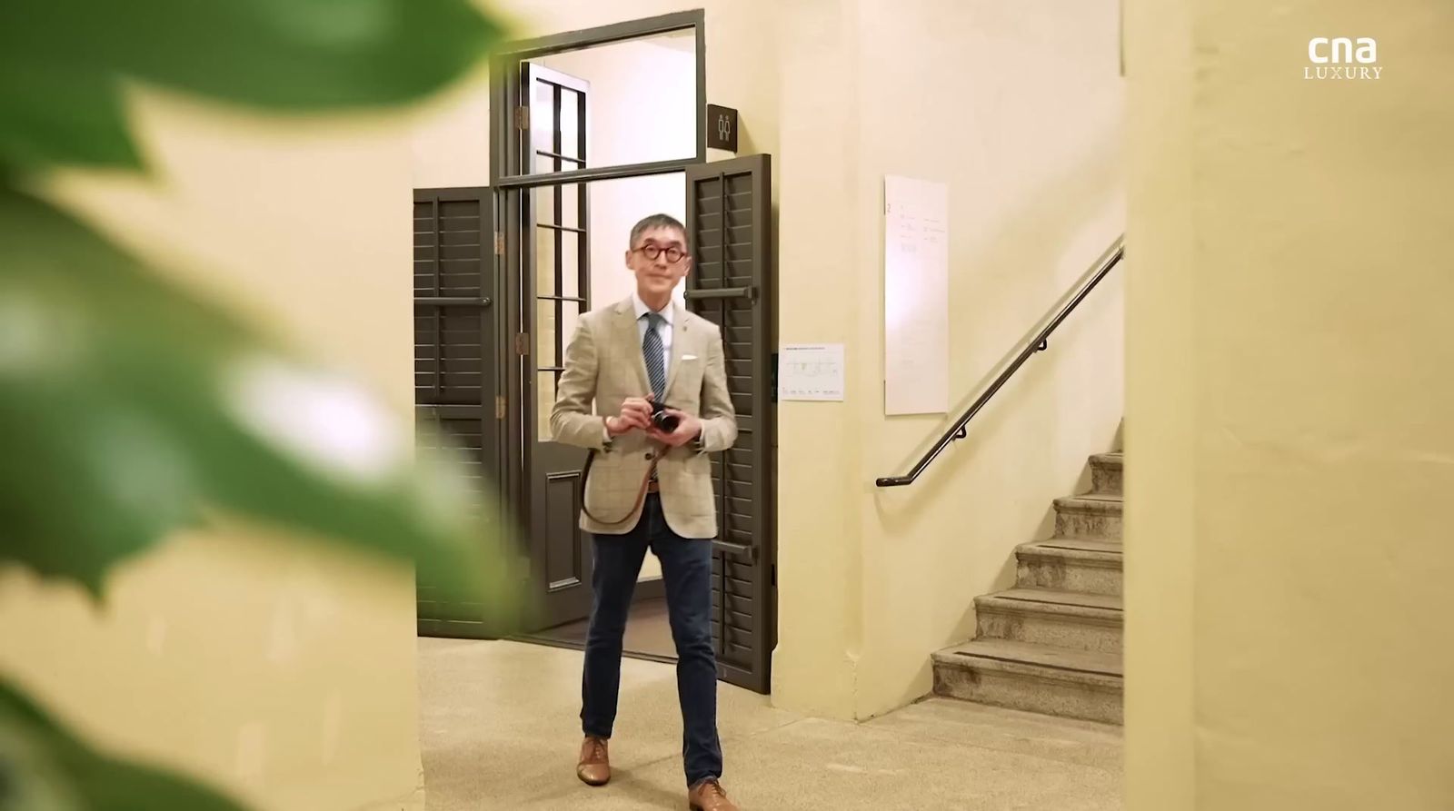 a man in a suit and tie standing in a doorway