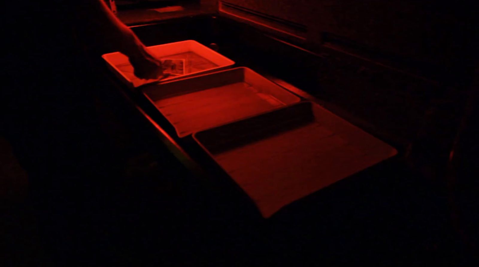 a person standing in a dark room with a red light