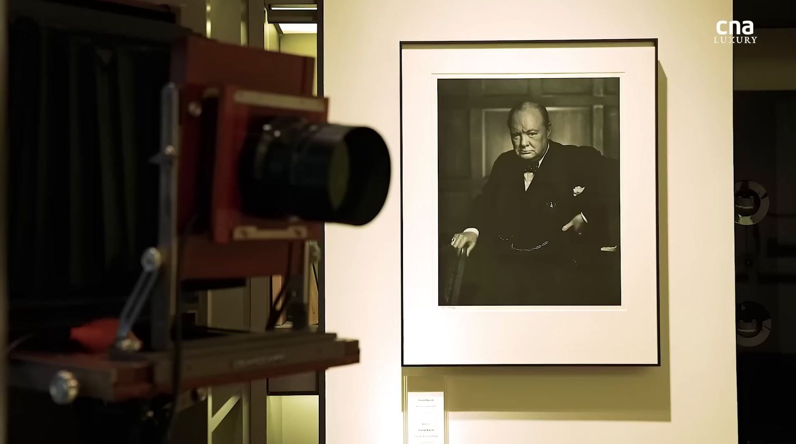 a photograph of a man sitting in a chair in front of a camera