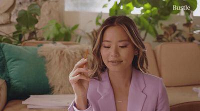 a woman sitting on a couch smoking a cigarette