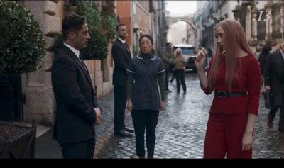 a group of people standing on a street next to each other