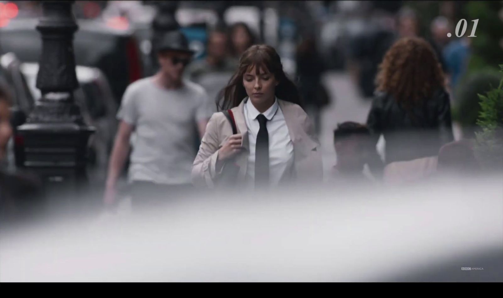 a woman in a tie walking down a street