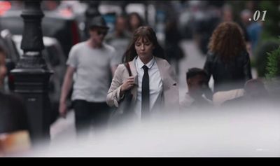 a woman in a tie walking down the street