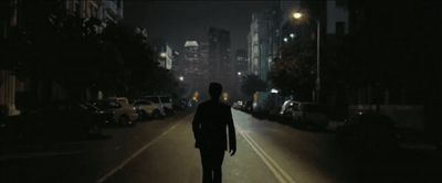 a man walking down a street at night