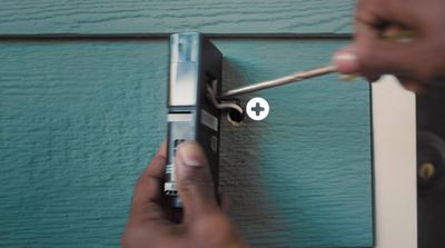 a person using a screwdriver to open a door