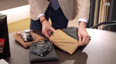 a man in a suit is opening a bag