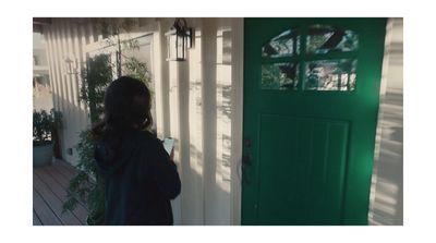 a woman standing in front of a green door