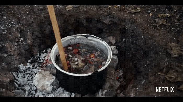 a bucket filled with food sitting on top of a pile of dirt