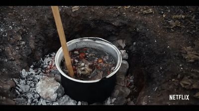 a bucket filled with food sitting on top of a pile of dirt