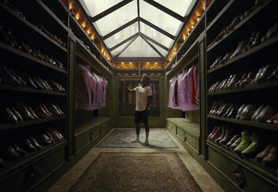 a man standing in a room with a lot of shoes