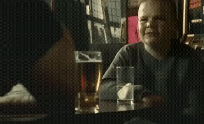 a man sitting at a table with a glass of beer