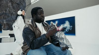 a man sitting on a bench holding a cell phone