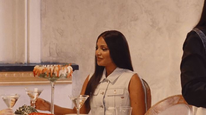 a woman sitting at a table with a plate of food