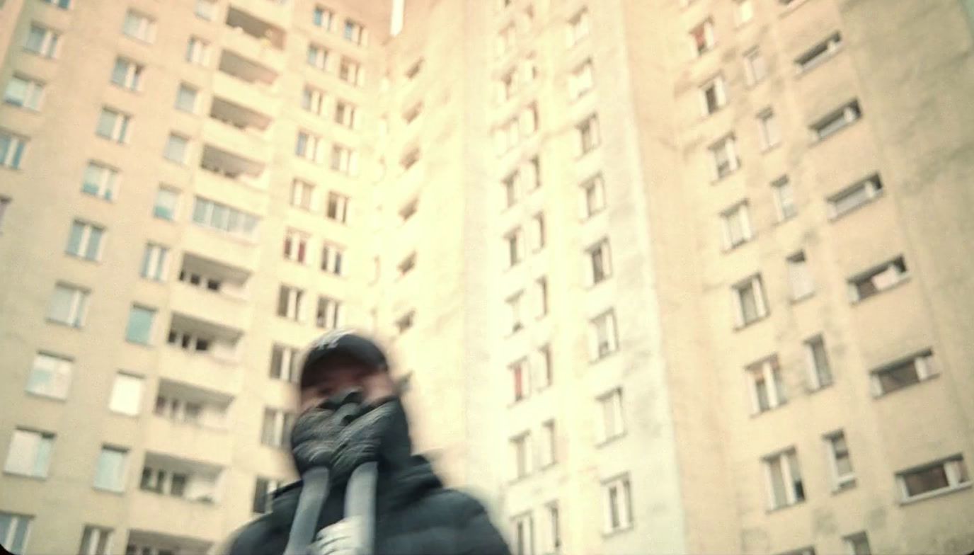 a blurry photo of a person walking in front of tall buildings