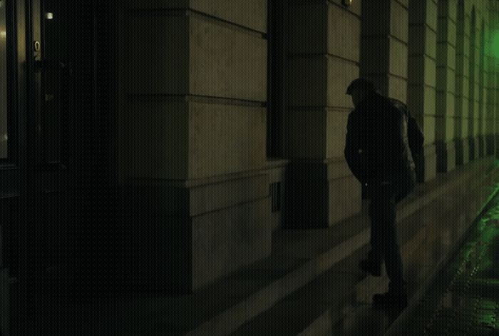 a man standing on a sidewalk next to a building