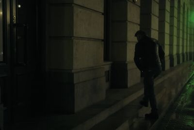 a man standing on a sidewalk next to a building