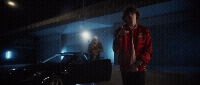 a man standing next to a car in a garage