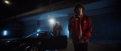 a man standing next to a car in a garage