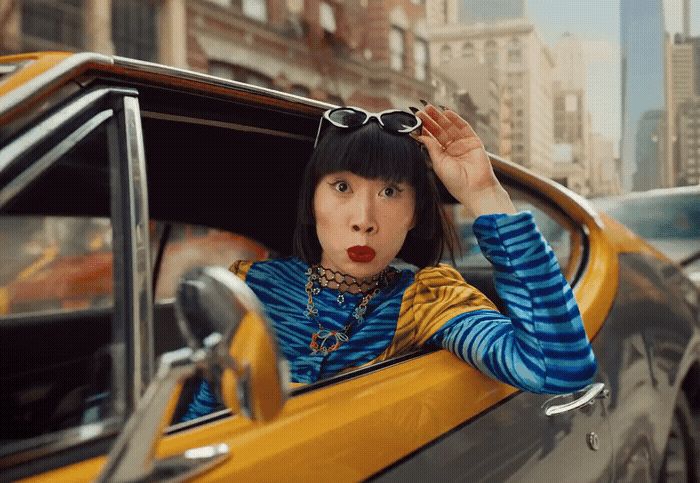 a woman sitting in a taxi cab with her hand on her head